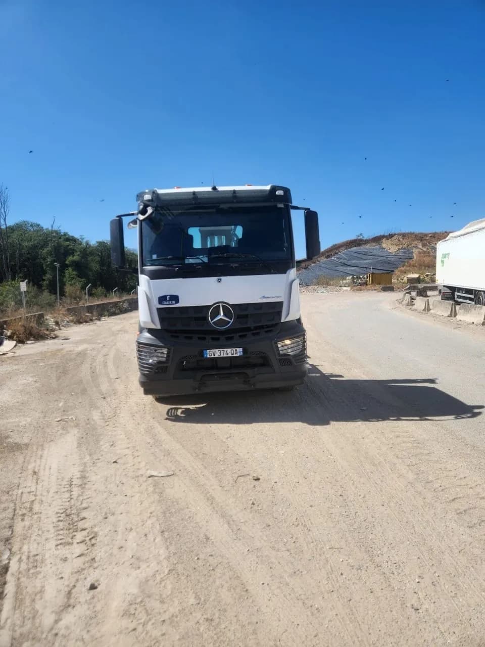 Camion T-K TRANSPORTS en intervention sur un chemin non revêtu